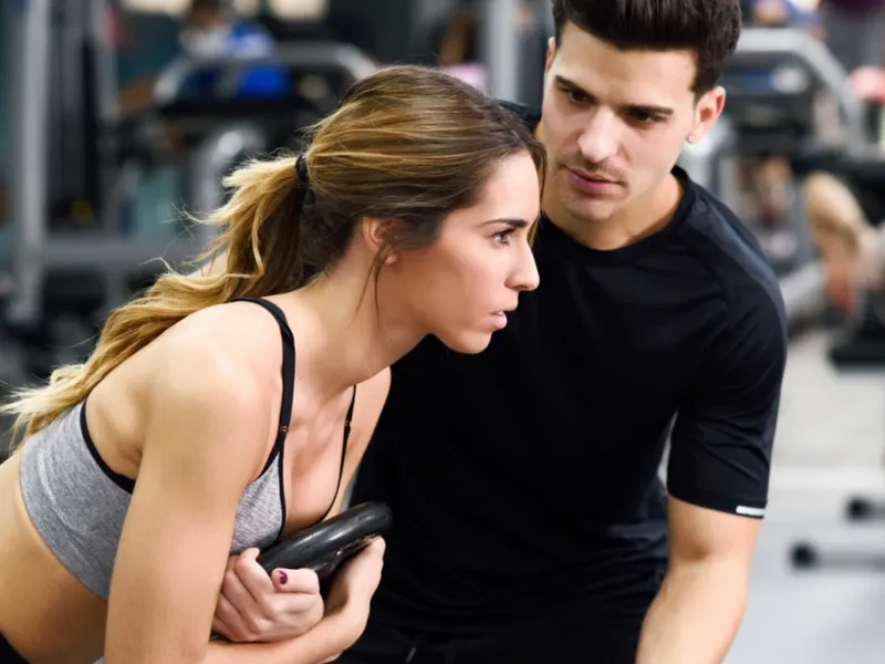 Personal trainer guiding a member through an exercise